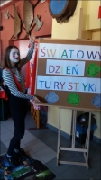 Uczennica przy plakacie z napisem Światowy Dzień Turystyki